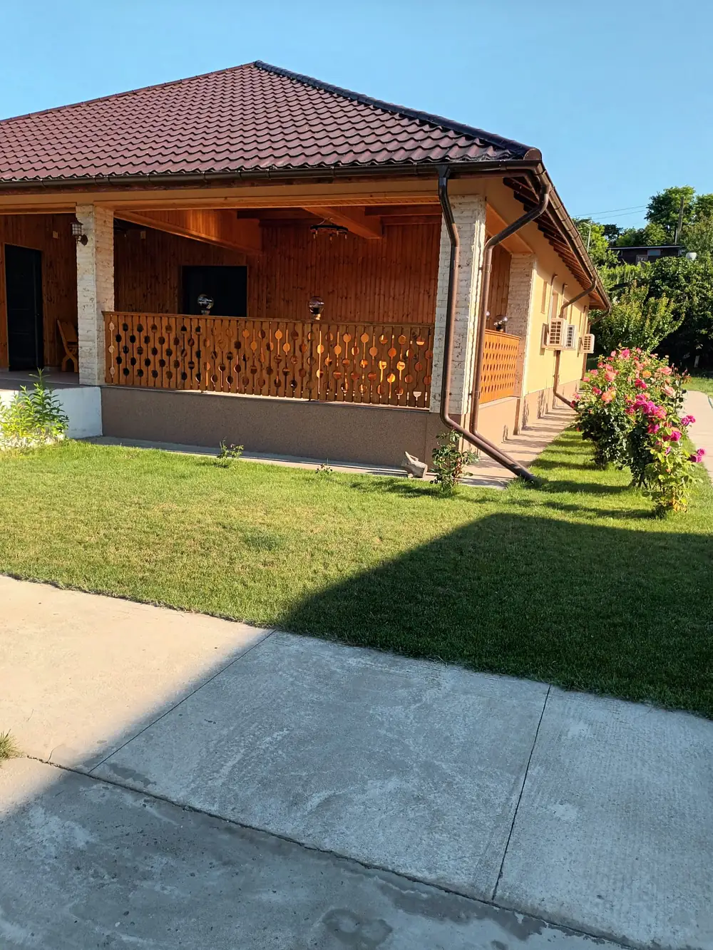 Terasa din lemn de lângă salon, cu trandafiri