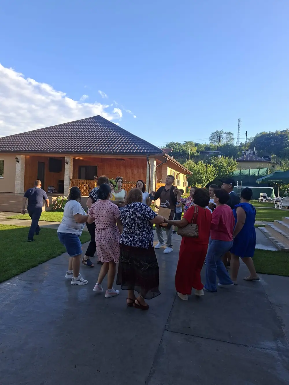 Invitați dansând hora în curtea pensiunii