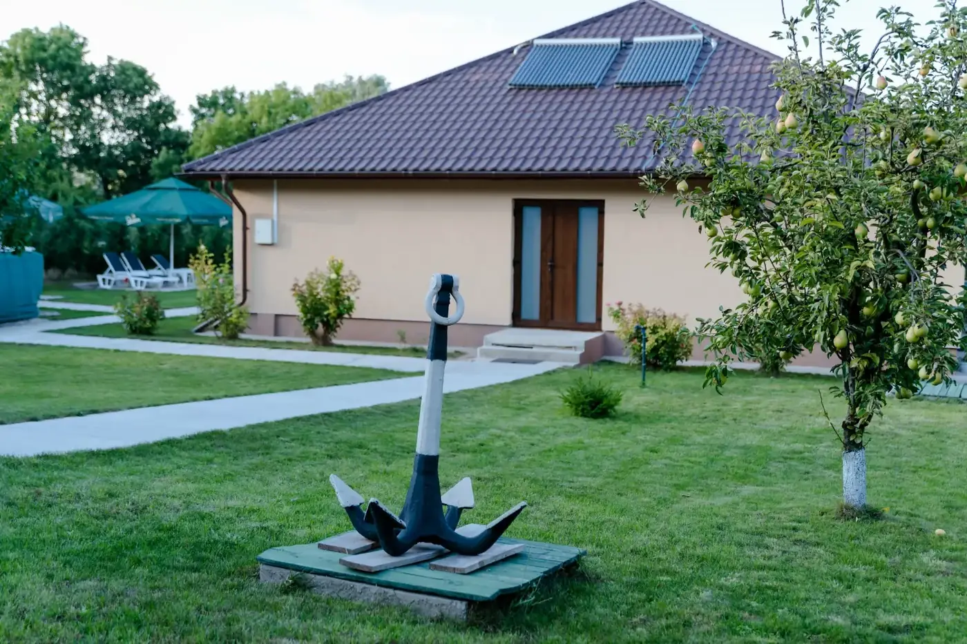 Clădirea cu camere a Pensiunii Dunărea, cu grădină și ancora din curte