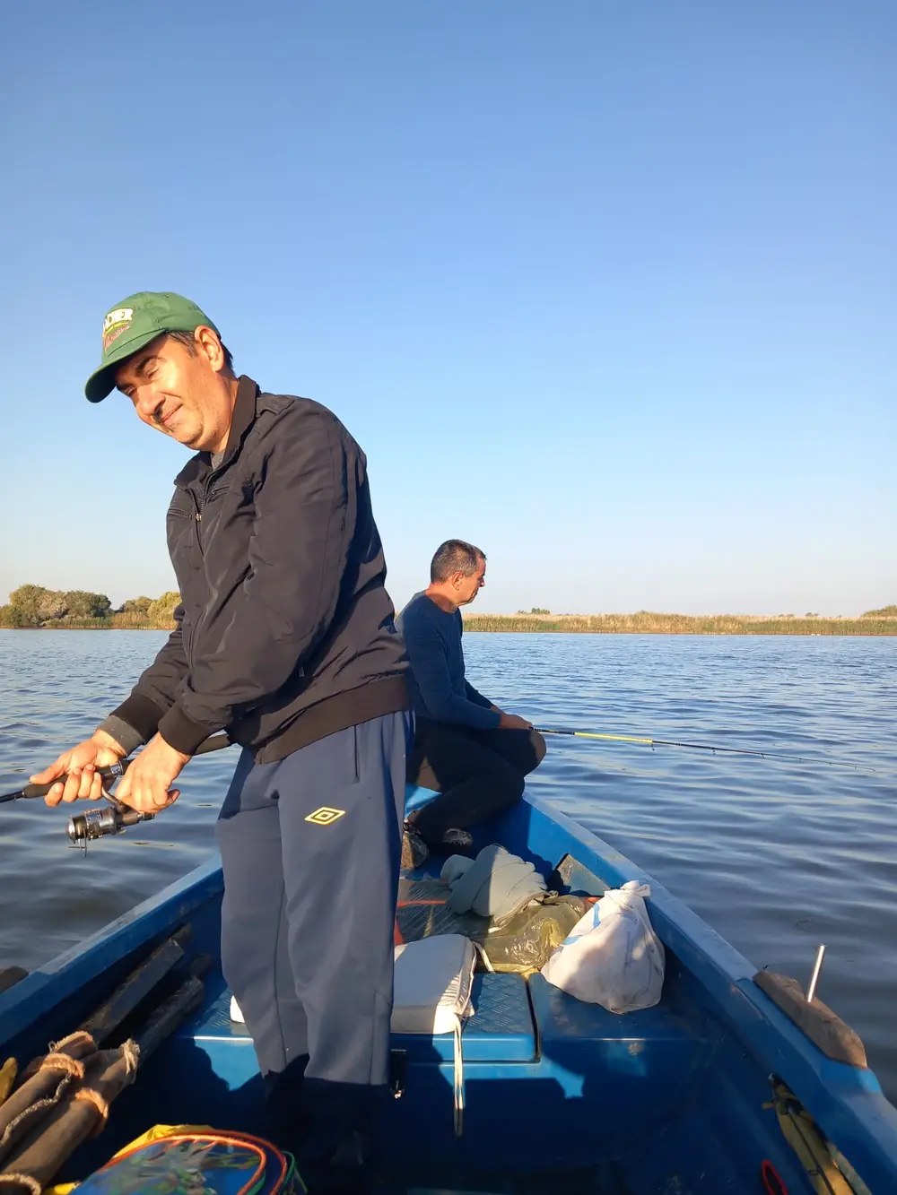 Pescari la spinning într-o barcă pe un lac din Deltă