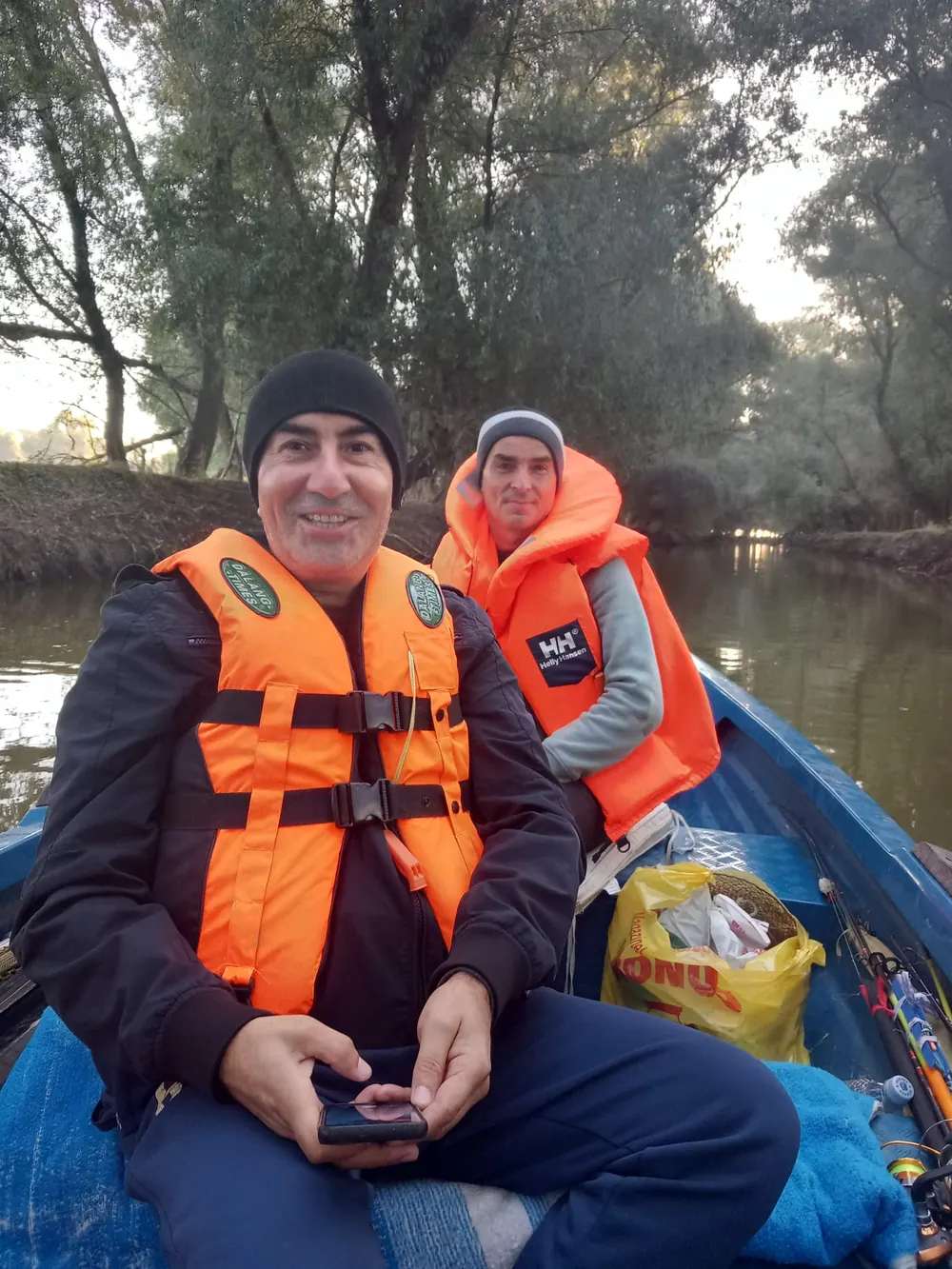 Pescari în barcă pe un canal din Delta Dunării, dimineața